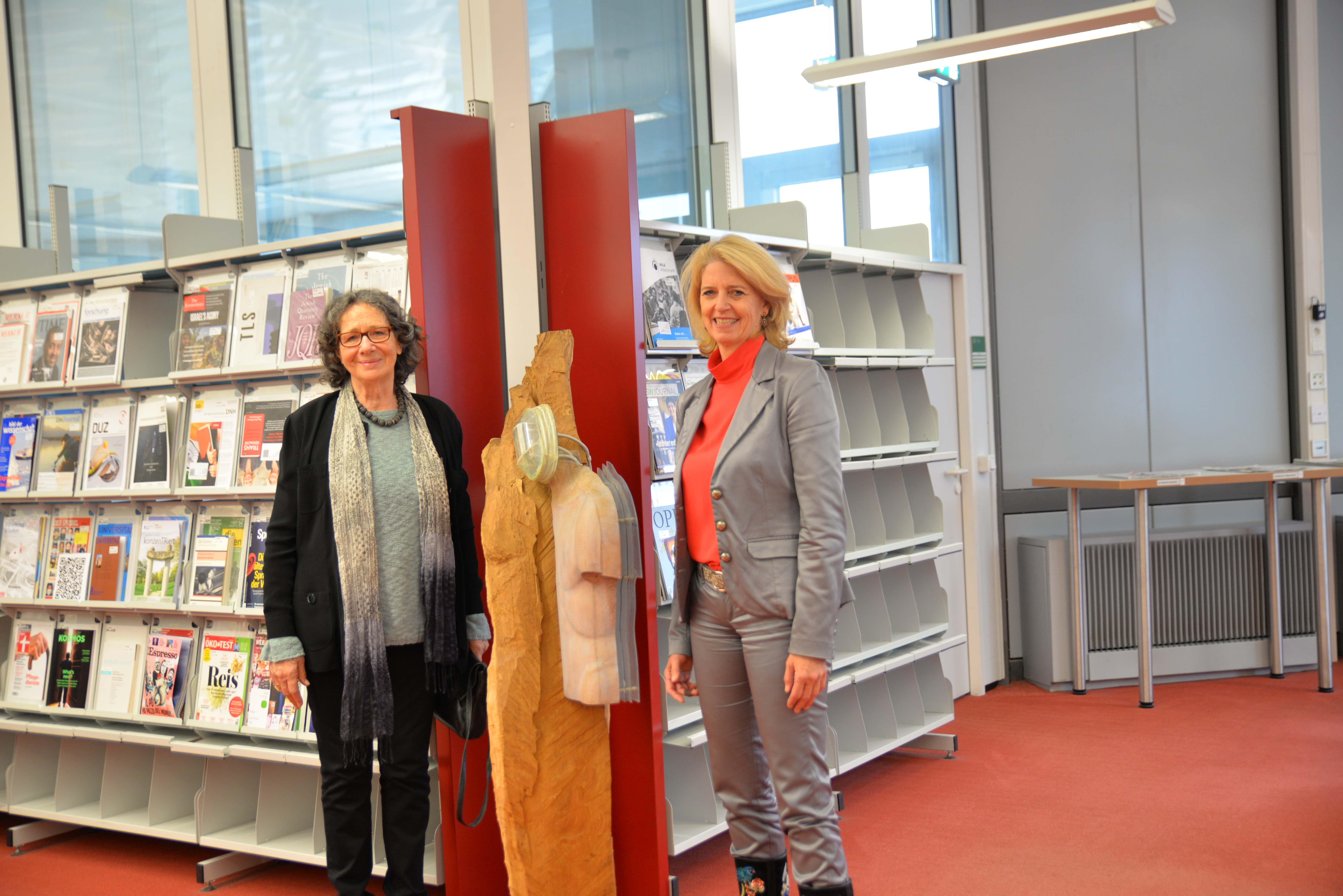 Gisela Siepmann-Wéber, die die Universität Trier mit einer Skulptur ihres verstorbenen Mannes Pierre Wéber beschenkte, und Universitätspräsidentin Prof. Dr. Eva Martha Eckkrammer freuen sich über das neue Kunstwerk in der Bibliothek.