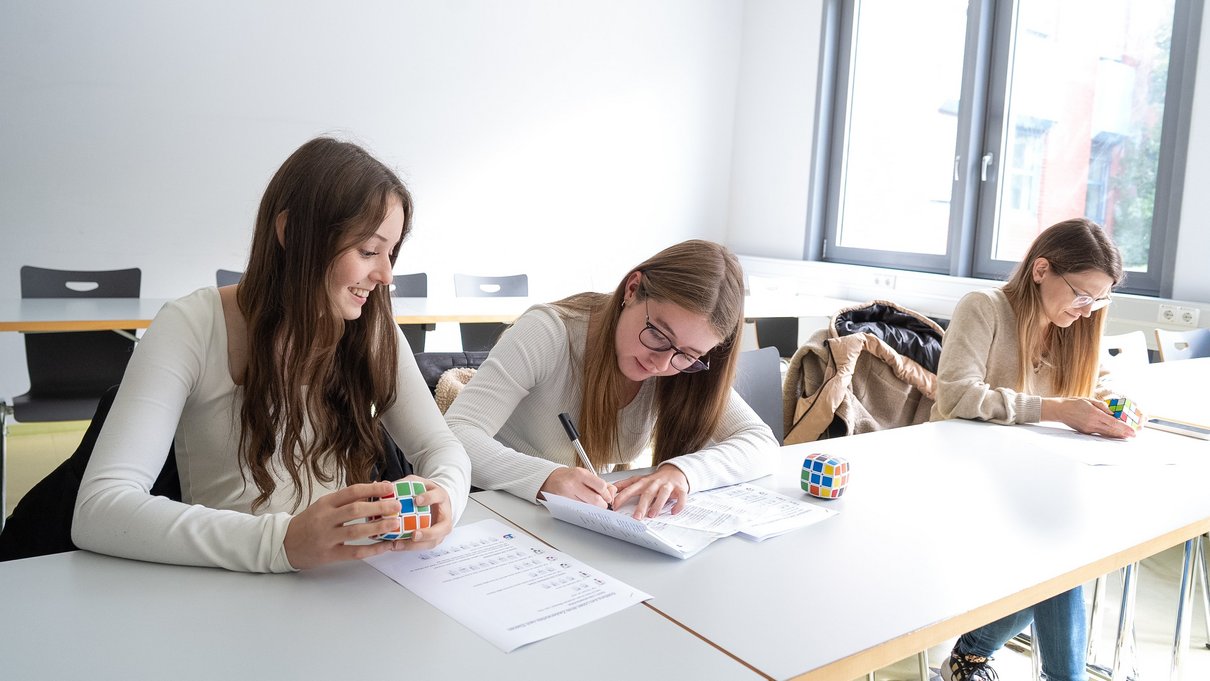 Beim „Tag der Mathematik“ an der Universität Trier haben sich Schülerinnen Wege erarbeitet, wie man einen Zauberwürfel lösen kann.