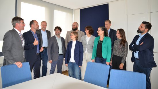 Gruppenfoto mit Wissenschaftsminister Unipräsident Jäckel, Minister Hoch, Vizepräsident Mattern und acht Nachwuchsforschende