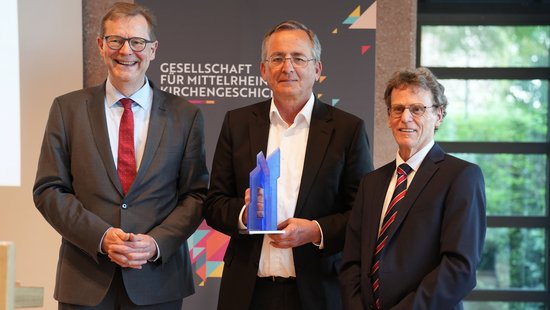 Der neue Vorsitzende Dr. Thomas Brockmann (links) und sein Vorgänger Prof. Dr. Bernhard Schneider (rechts) würdigen Prof. Dr. Wolfgang Schmid mit der Ehrengabe der Gesellschaft.
