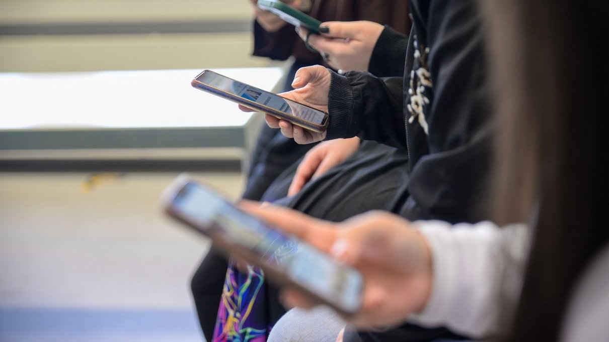 Drei Hände, die Smartphones halten