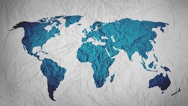 Eine gemalte Weltkarte. Die Kontinente sind in blauer Farbe, der Hintergrund ist als verknittertes Papier dargestellt.