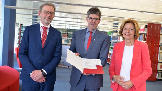 Ministerpräsidentin Malu Dreyer übergab in der Universitätsbibliothek den Förderbescheid an Michael Jäckel (Universitätspräsident) und Andreas Regelsberger (Dekan des Fachbereichs II).