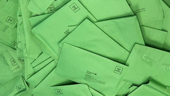 Grüne Wahlbriefe auf einem ungeordneten Stapel