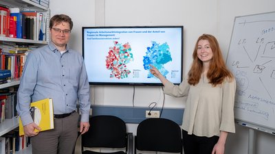 Jörn Block und Natalie Welch vor einer interaktiven Karte. 