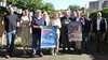 Gruppenbild mit elf Männern und Frauen mittleren Alters, jeweils zwei Personen halten ein Plakat vom City Campus bzw. der Illuminale