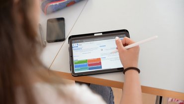 Person sitting in front of a tablet showing the Porta homepage.