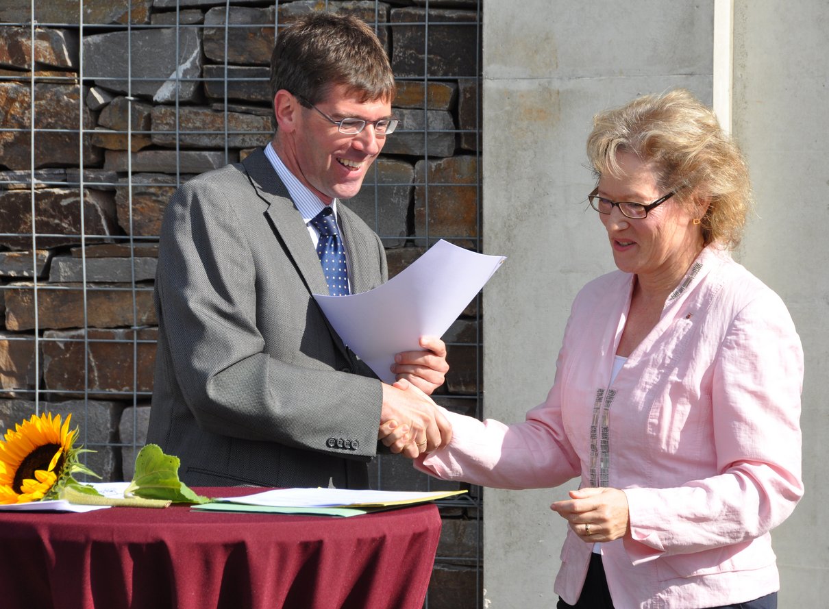 Dagmar Barzen, Präsidentin der Aufsichts- und Dienstleistungsdirektion, und Universitätspräsident Prof. Dr. Michael Jäckel beim Austausch der unterzeichneten Verträge zur Weinbergspatenschaft.