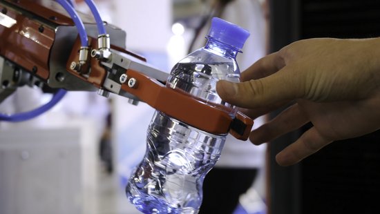 Symbolfoto von einem Roboterarm der eine Wasserflasche anreicht. Foto: Colourbox.de