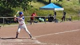 Mann in blau-weißer Baseball-Uniform wartet auf einen heranfliegenden Softball, um ihn zu schlagen