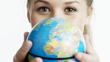 Frau hält kleinen Globus