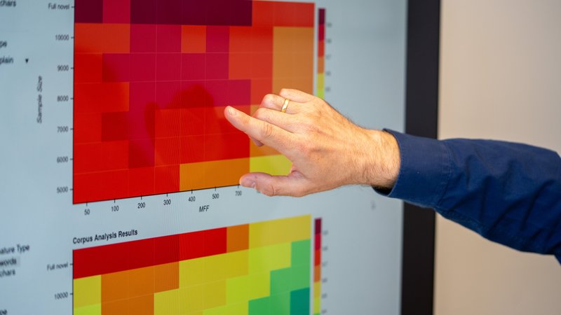 Hand zeigt etwas auf einer Grafik am Bildschirm
