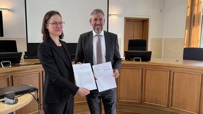 Die Dekanin des Fachbereichs Rechtswissenschaft, Prof. Dr. Birgit Peters, LL.M. (London) und PräsOLG Thomas Henrichs bei der feierlichen Unterzeichnung. Foto: OLG Koblenz 