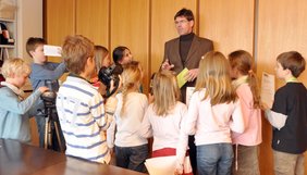 „Medienrummel“ an der Universität: Die Reporter der Kinderuni bestürmen Präsident Prof. Dr. Michael Jäckel mit ihren Fragen.