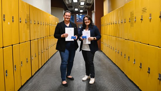 Lehrpreisträgerinnen im Flur, links und rechts gelbe Schließfächer