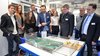 Hannes Schmalor, Leiter des Faches Geographie und ihre Didaktik, zeigt unter anderem Universitätspräsident Michael Jäckel (3. v. r.) ein Hochwassermodell.