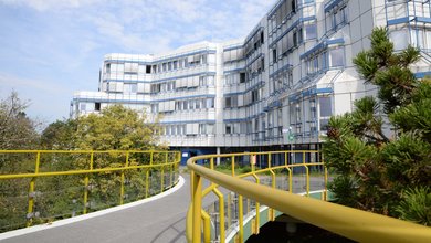 Foto des Gebäudes D der Psychologie am Campus I mit Brücke im Vordergrund.