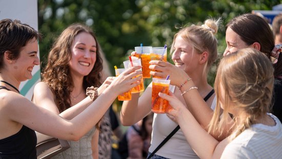 5 Studentinnen heben die Cocktailbecher zusammen