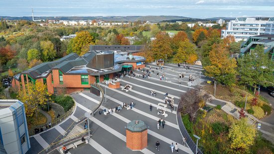 Campusaufnahme vom Forum mit Mensa und Studierenden auf dem Campus