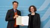 Minister Lauterbach überreicht Professorin Melanie Messer die Urkunde.
