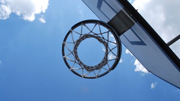 Basketballkorb von unten durchs Netz fotografiert.