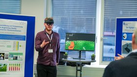 [Translate to Englisch:] Mann mit VR-Brille vor Computer
