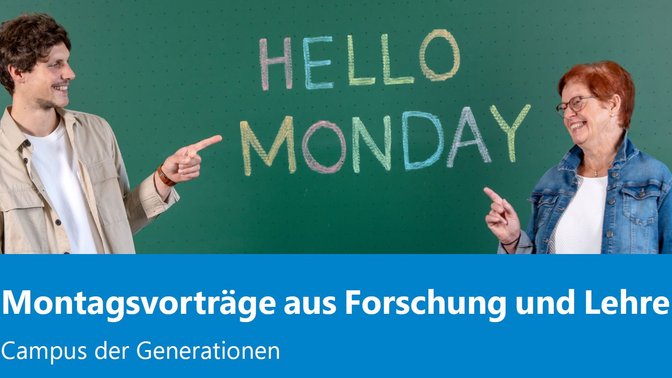 zwei Gäste der Montagsvorträge (jüngerer Mann und ältere Frau) zeigen auf Tafel: Hello Monday