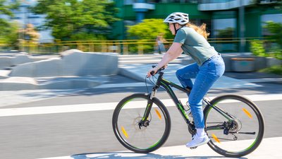 Frau fährt mit dem Fahrrad über das Forum. 