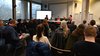 Seminarsaal mit Besuchern von hinten und vorne die Podiumsdiskussion