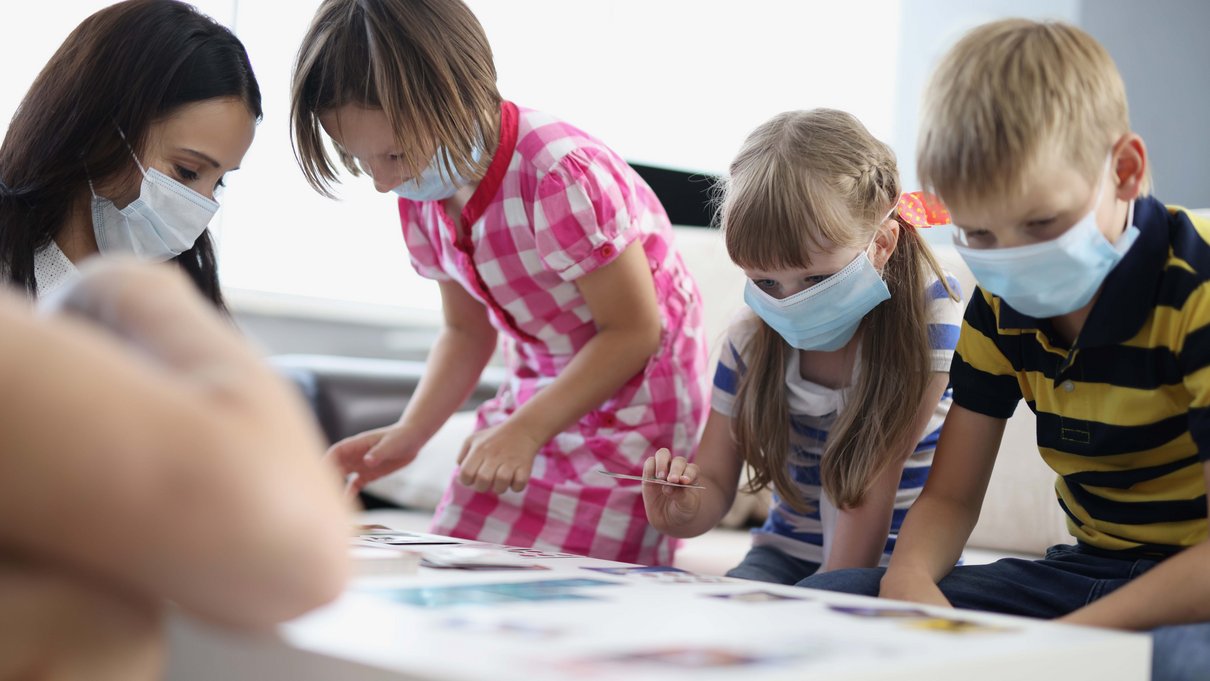 Kinder mit einer Erzieherin beim Spielen.