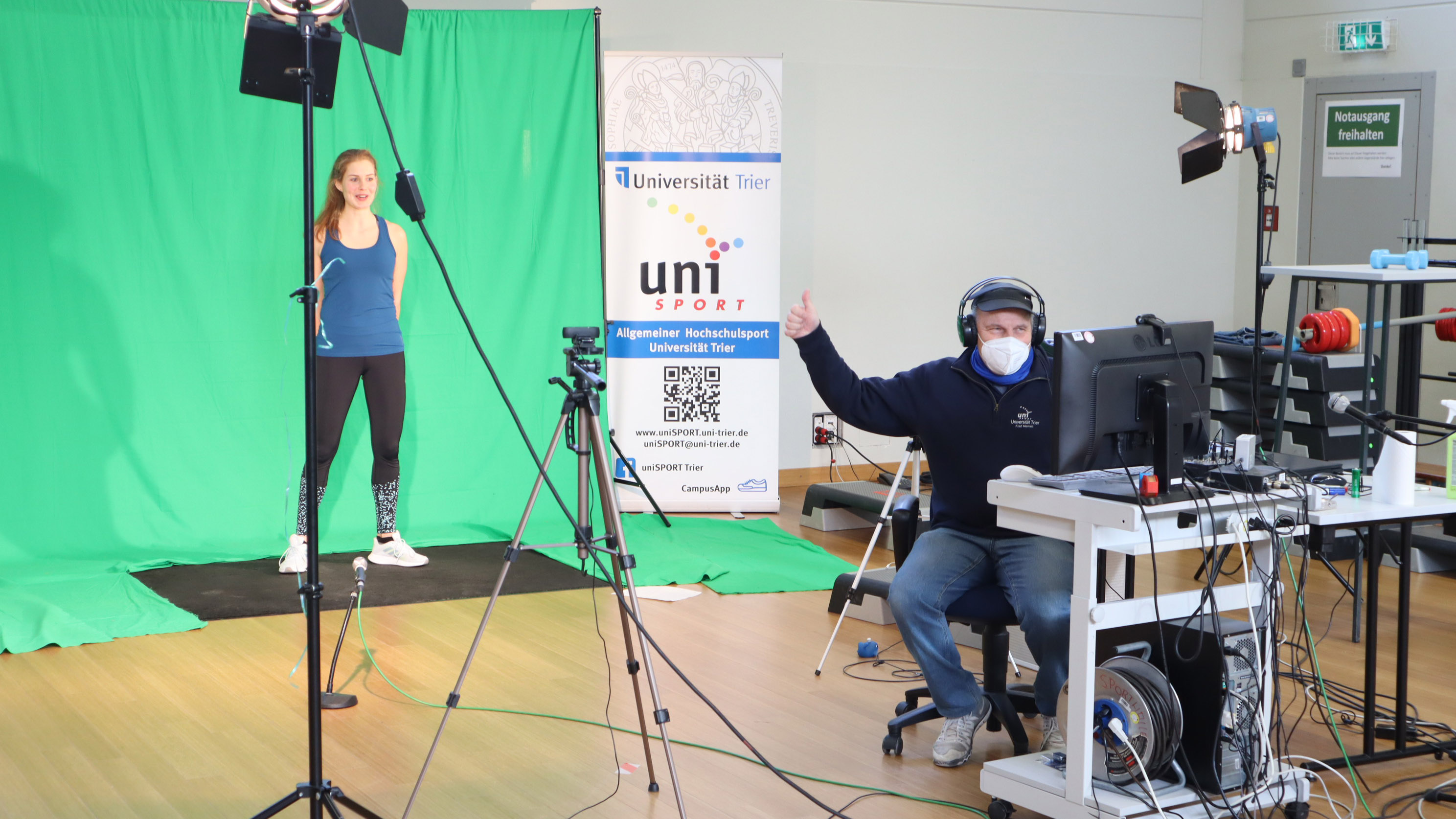 „Der uniSPORT der Universität Trier hat sich ein Filmstudio in der Sporthalle eingerichtet, aus dem Liveworkouts für das neue Bewegungsförderprogramm BEST live gestreamt oder auch aufgenommen werden.“