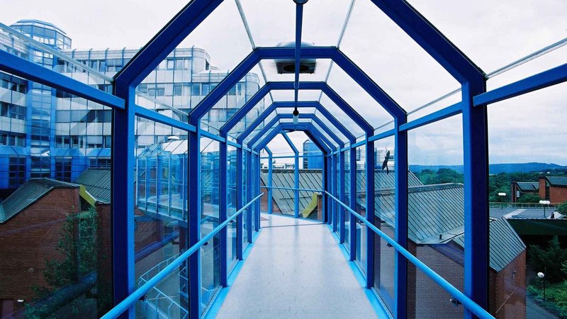 gläserne Bibliotheksbrücke mit blauem Stahlrahmen
