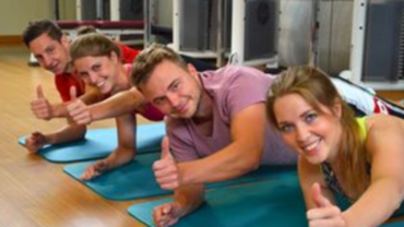Junge Menschen zeigen den Daumen hoch während sie Sport machen.
