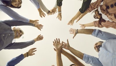 Team hält die Hände gemeinsam in die Luft