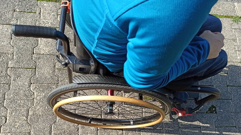 Rolli-Fahrer auf Bürgersteig